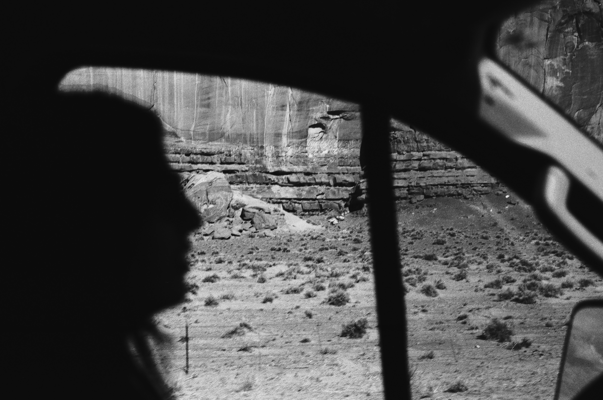 Silhouette against Monument Valley cliffs on 35mm film, analog black and white