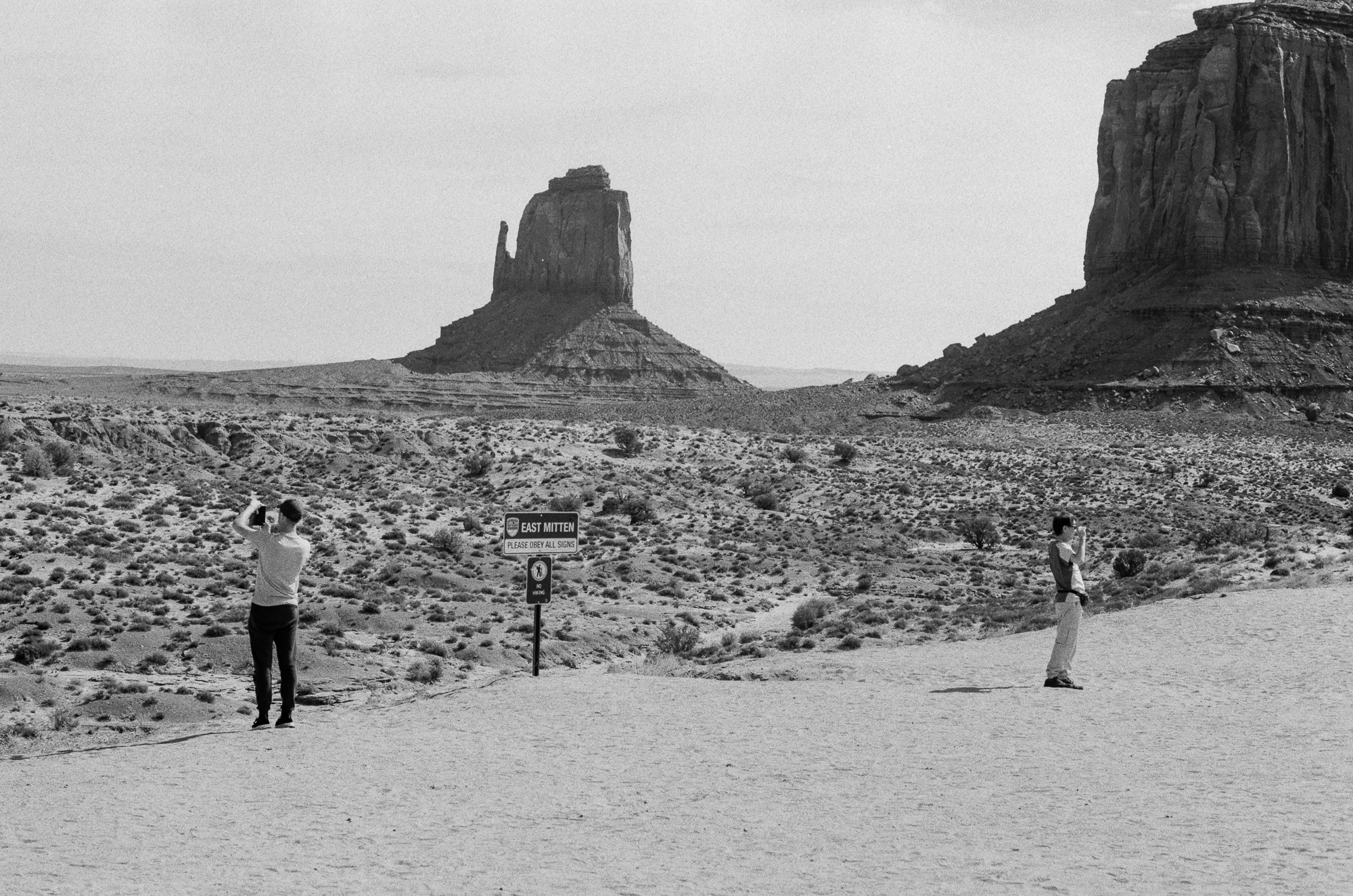 Tourists photographing East Mitten Butte at Monument Valley, 35mm analog black and white