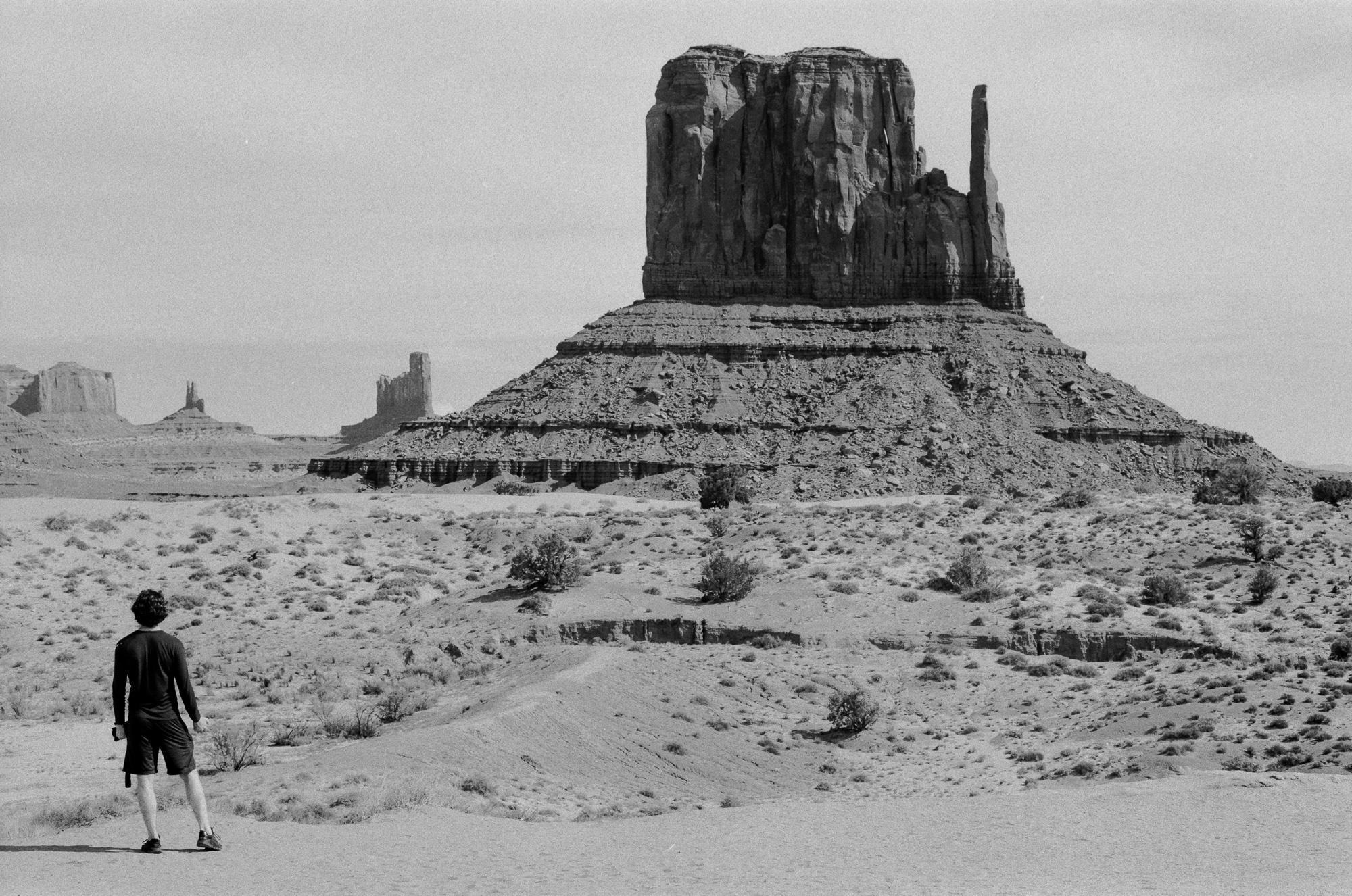 Lone figure beneath West Mitten Butte at Monument Valley, 35mm analog black and white