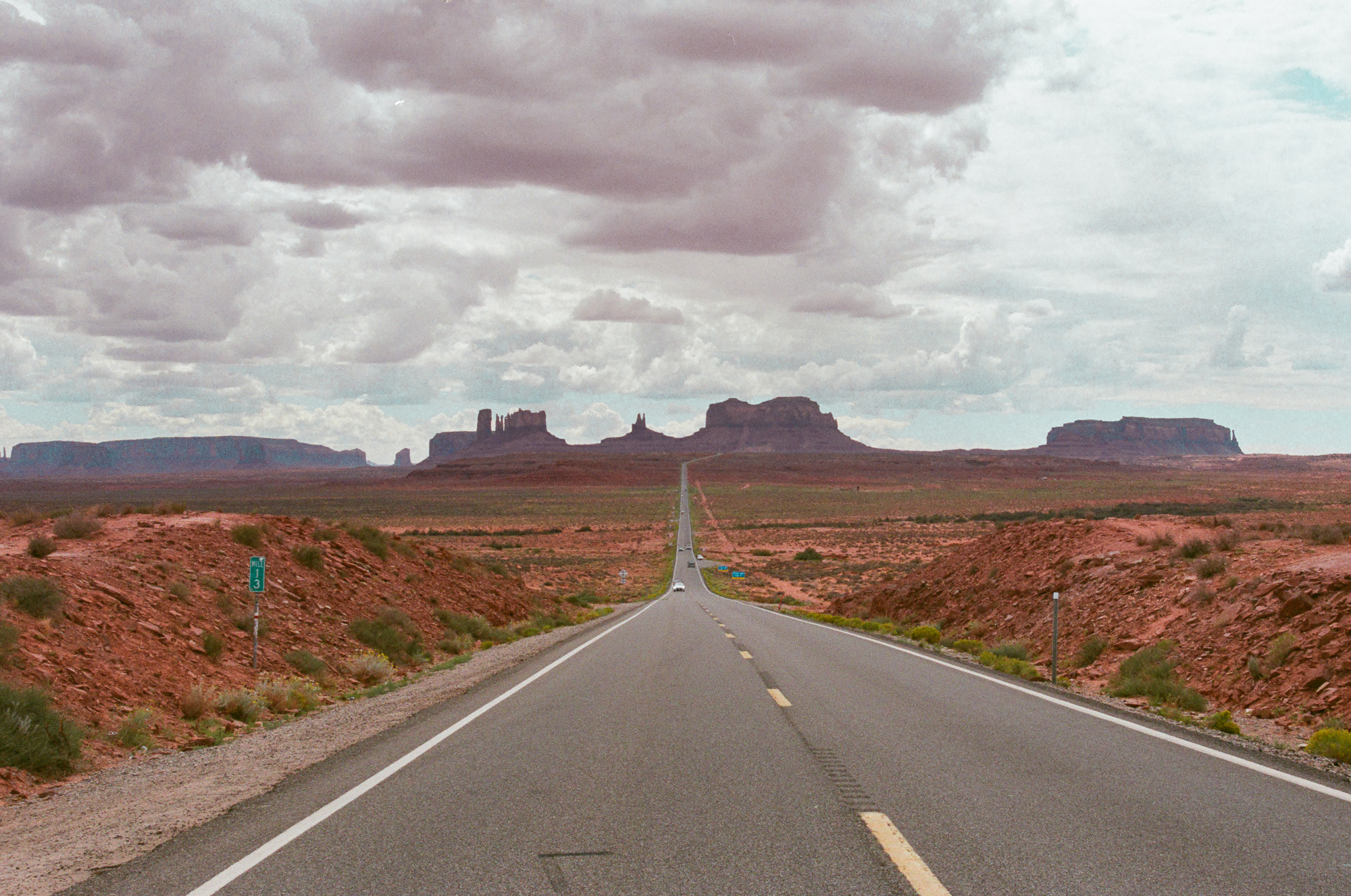 US-163 highway approaching Monument Valley buttes, 35mm film, analog black and white