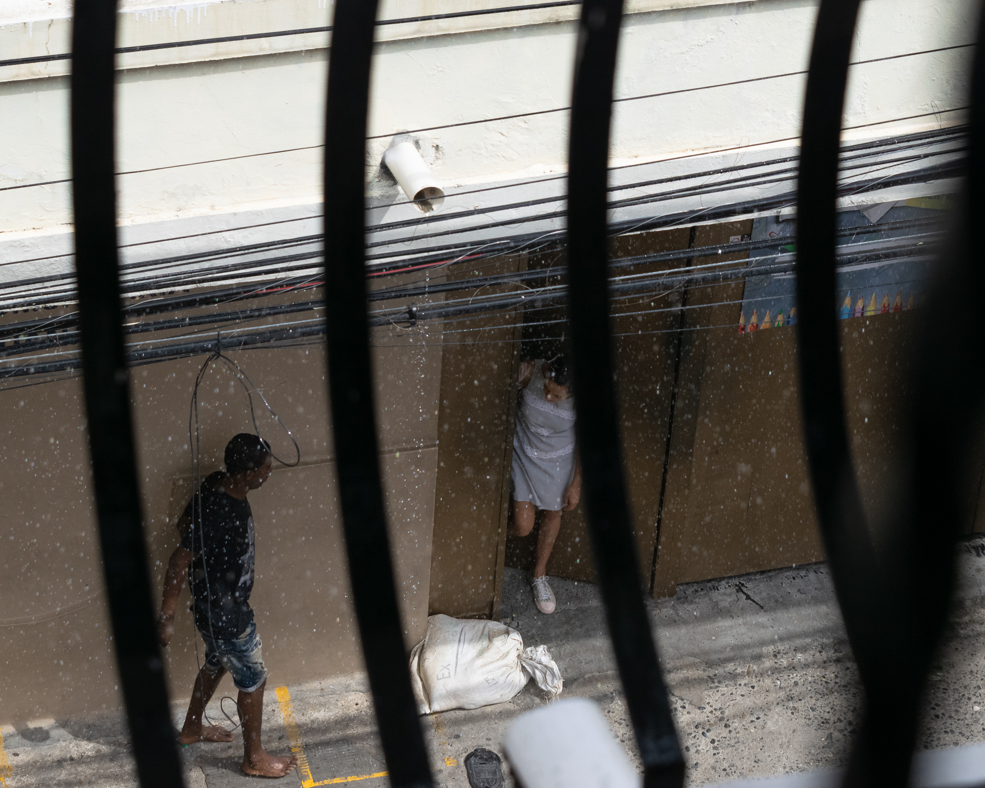 A couple sheltering from rain in Santo Domingo — tender, candid, vulnerable