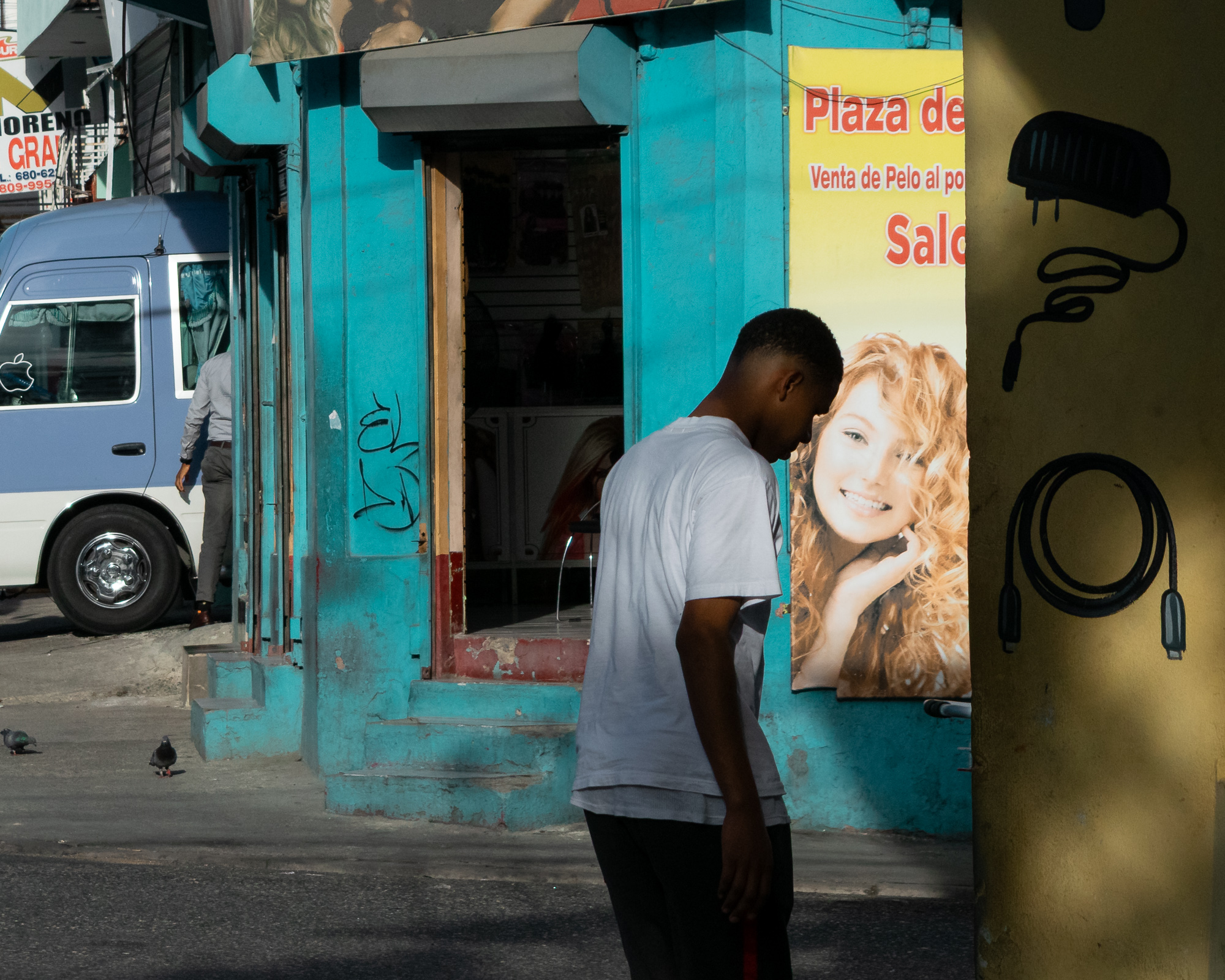 A solitary figure at a pedestrian crossing in Santo Domingo, bathed in late-afternoon glow