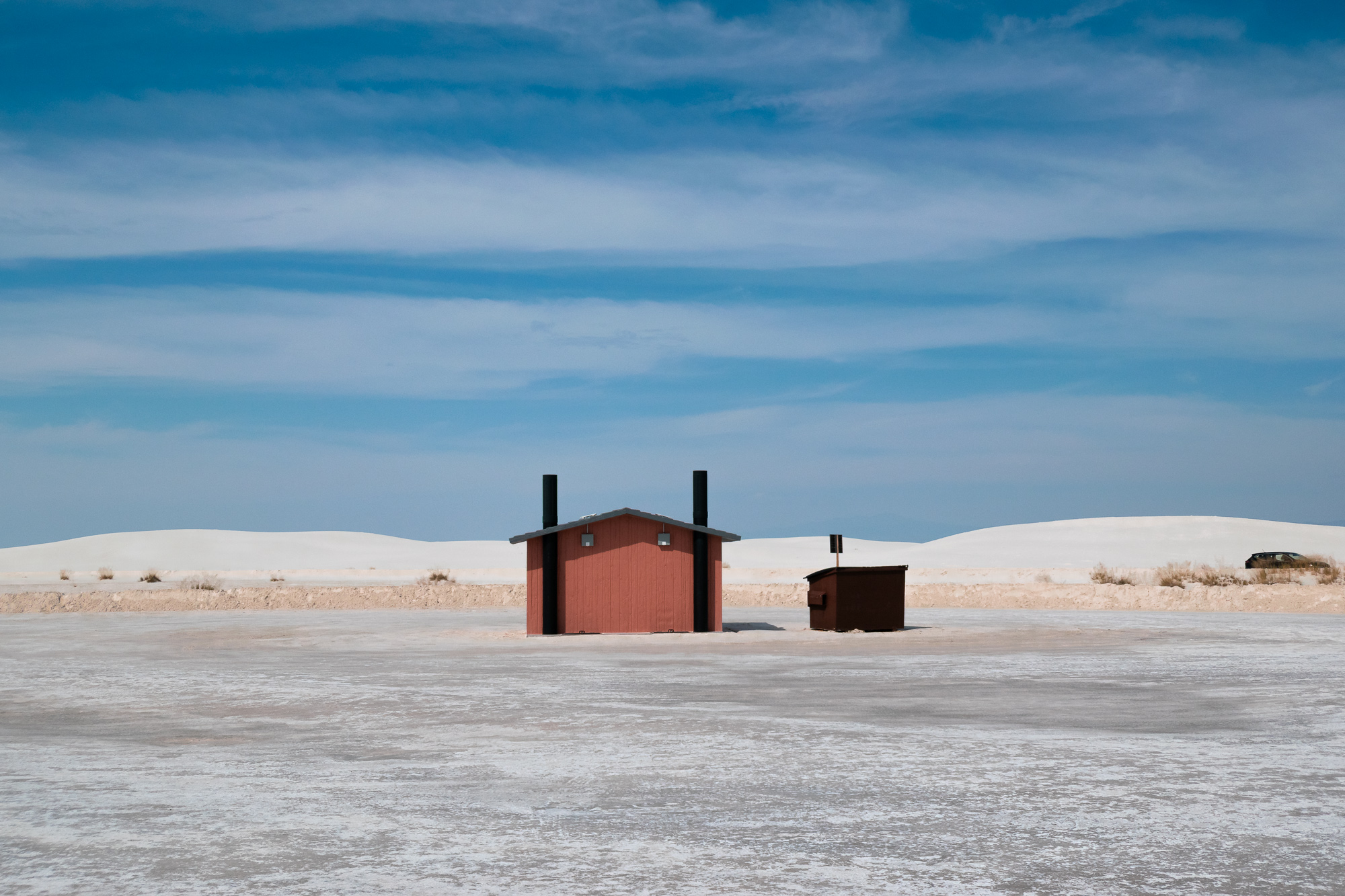 Red restroom hut and dumpster on the gypsum flat, White Sands, New Mexico