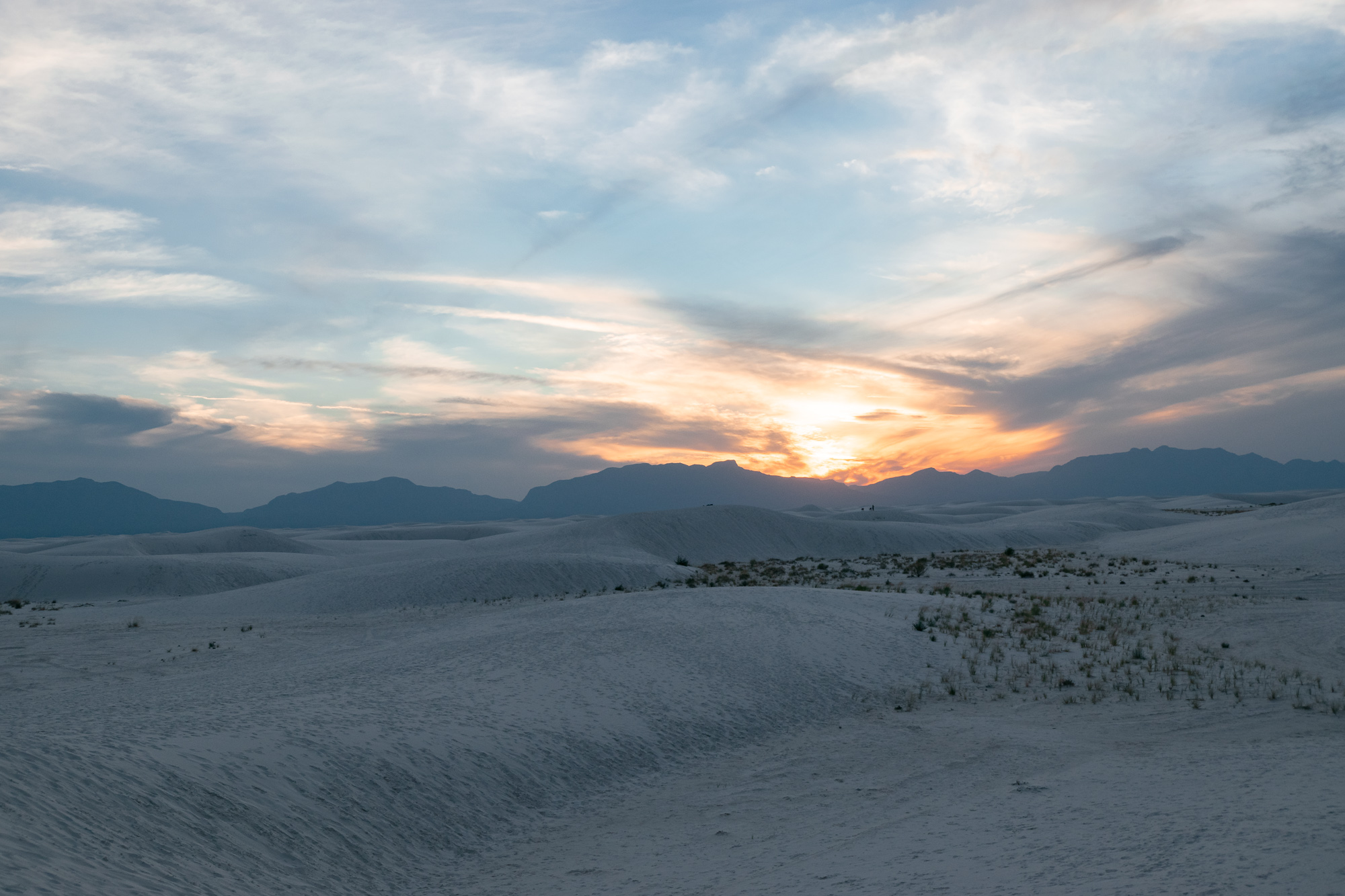 Sunset over White Sands dunes and distant mountains