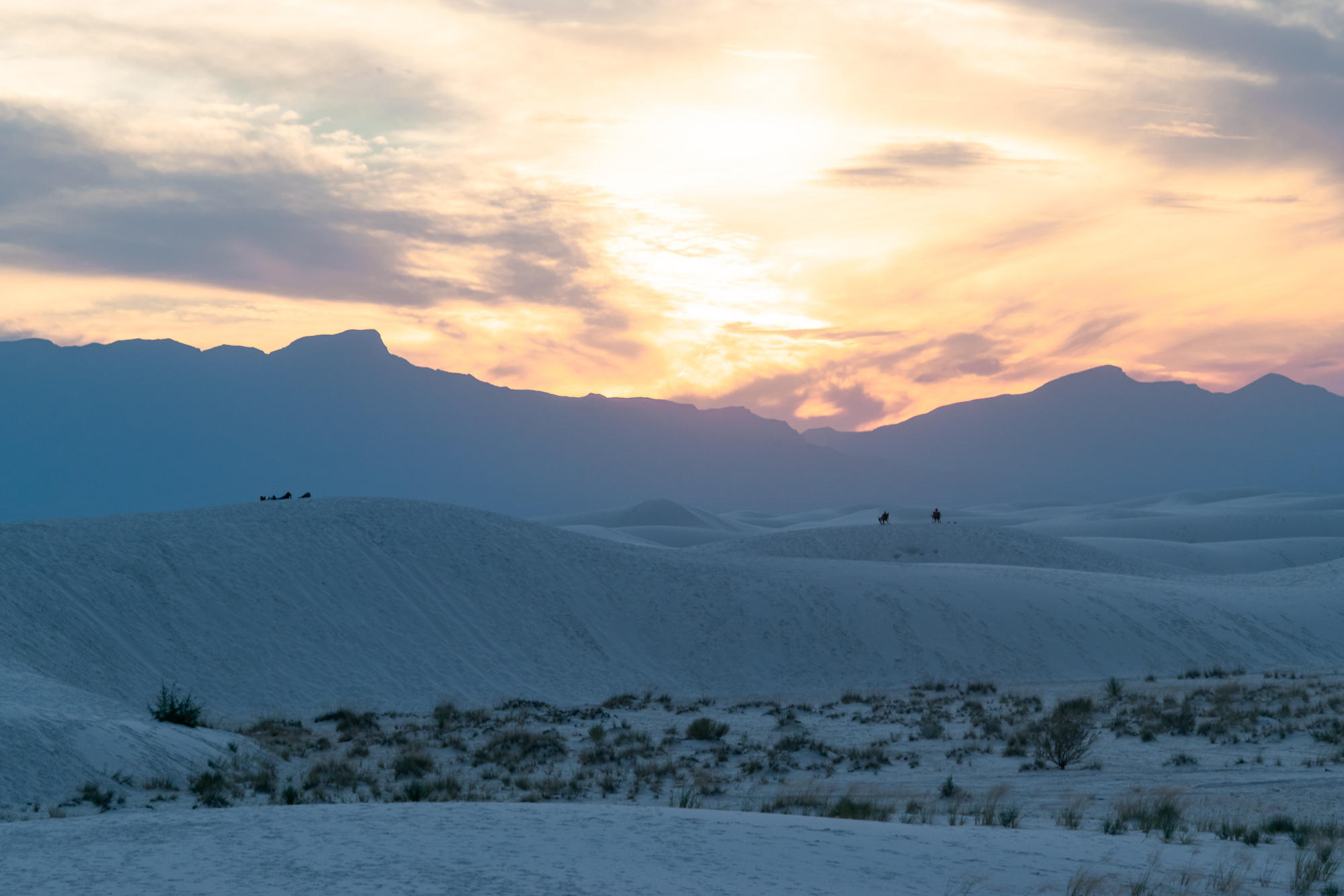 Riders on White Sands dunes at sunset