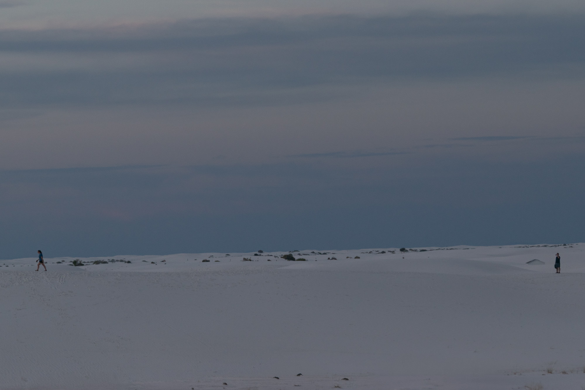 Two figures on White Sands dunes at dusk