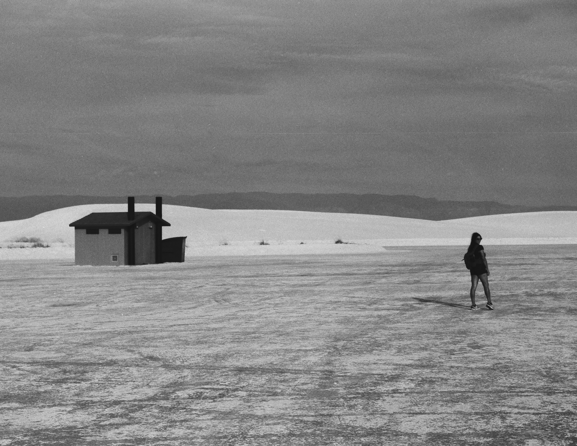 Lone figure and restroom hut at White Sands, 35mm film